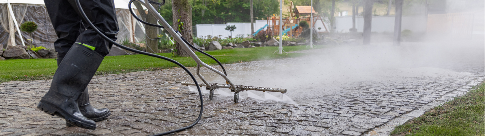 Power washing a stone pathway outdoors.