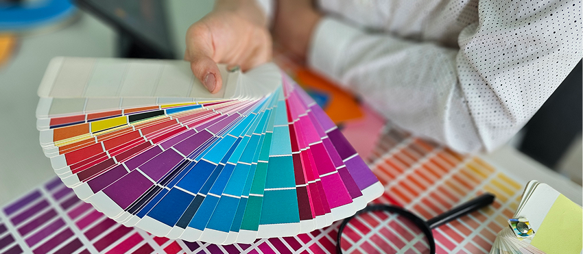 Choosing colors in a design studio while holding color swatches and examining options