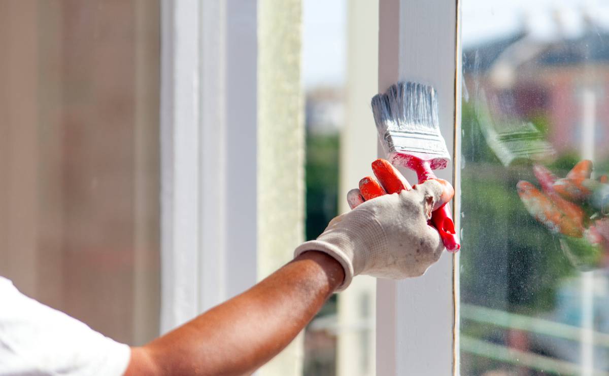 Painting a window frame with brush