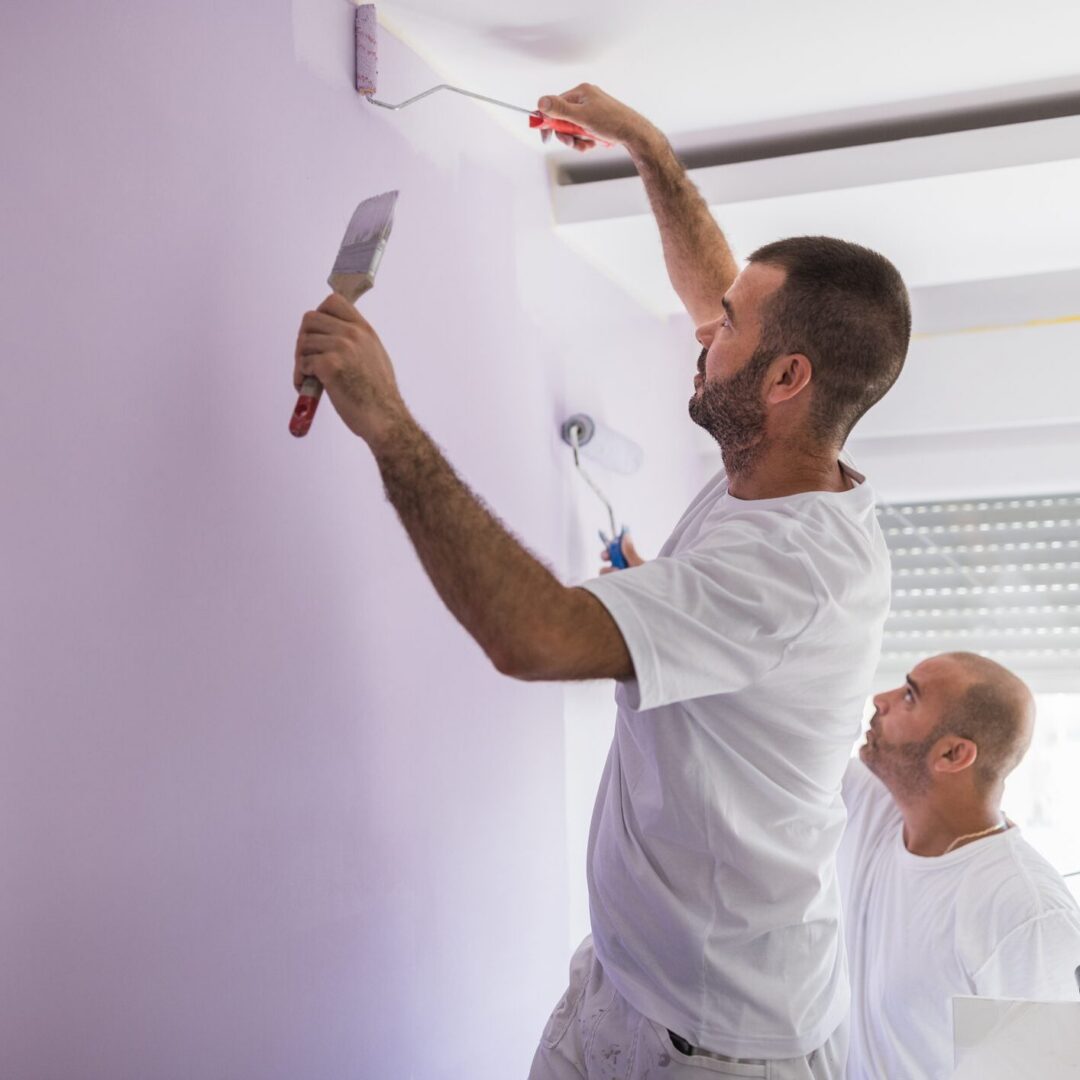 Painter applying purple paint indoors