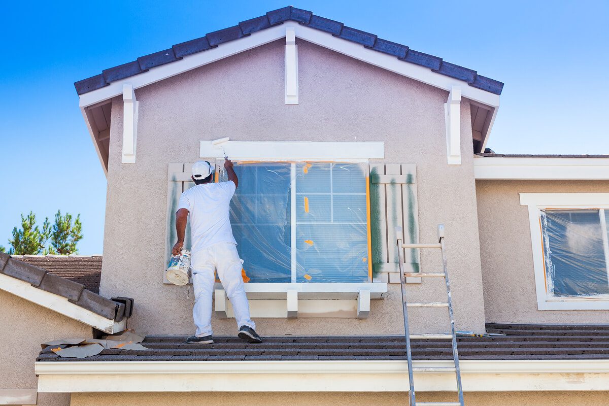 Man painting house walls white