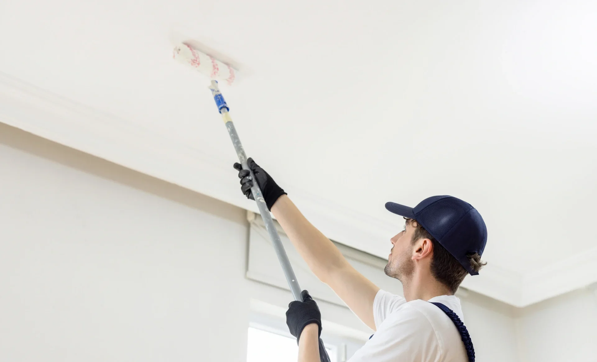 Worker male painting ceilings