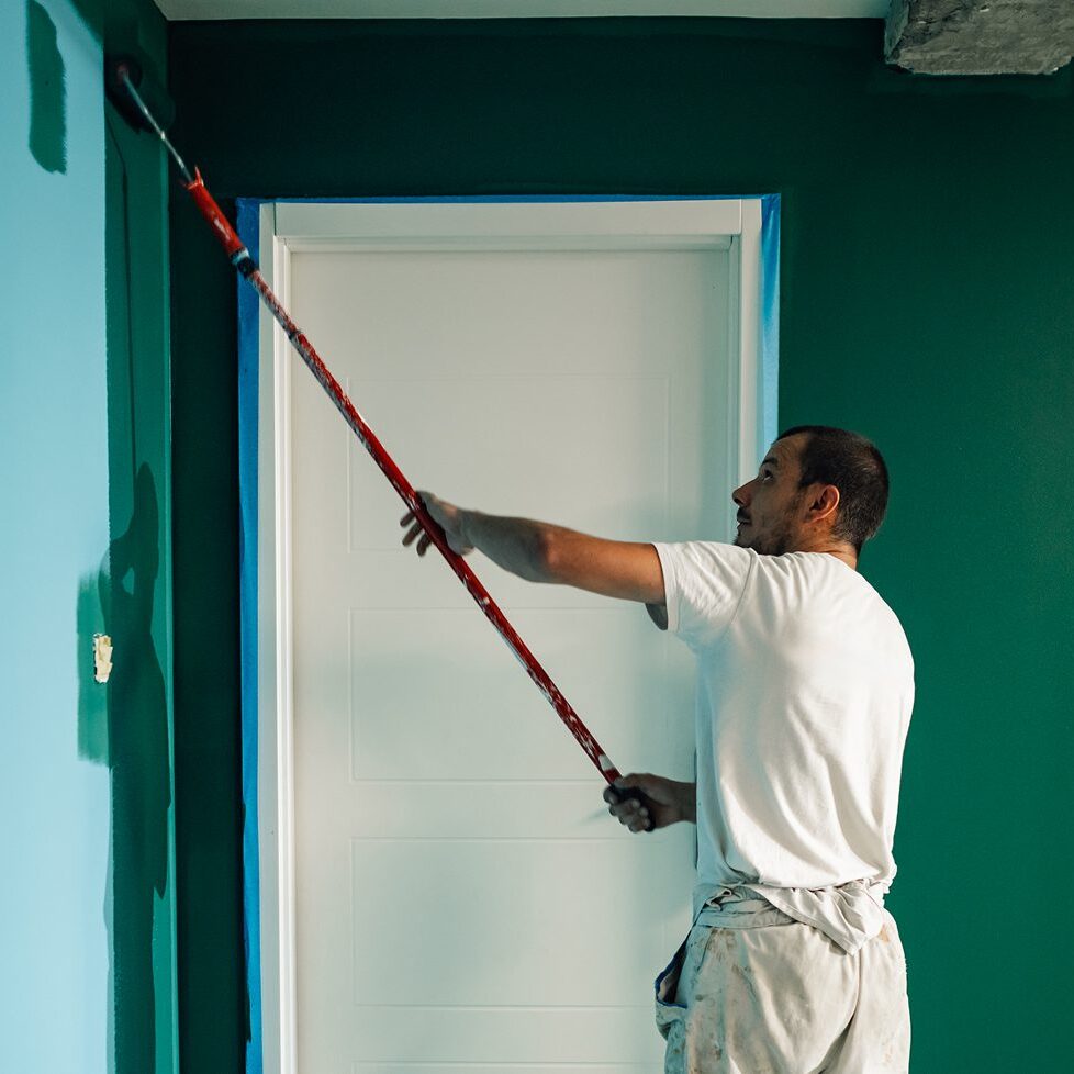Man painting wall with roller