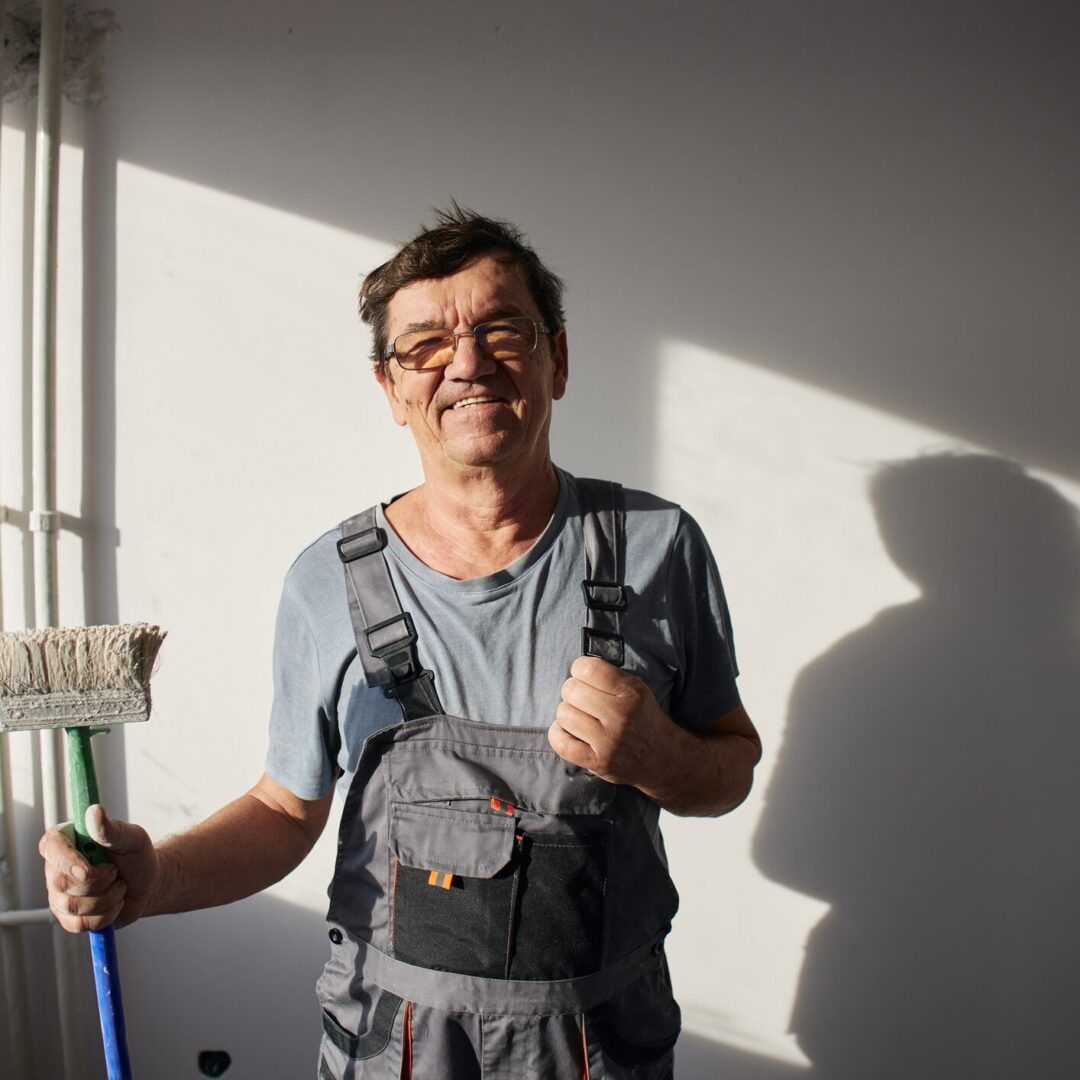 Man holding a mop smiling