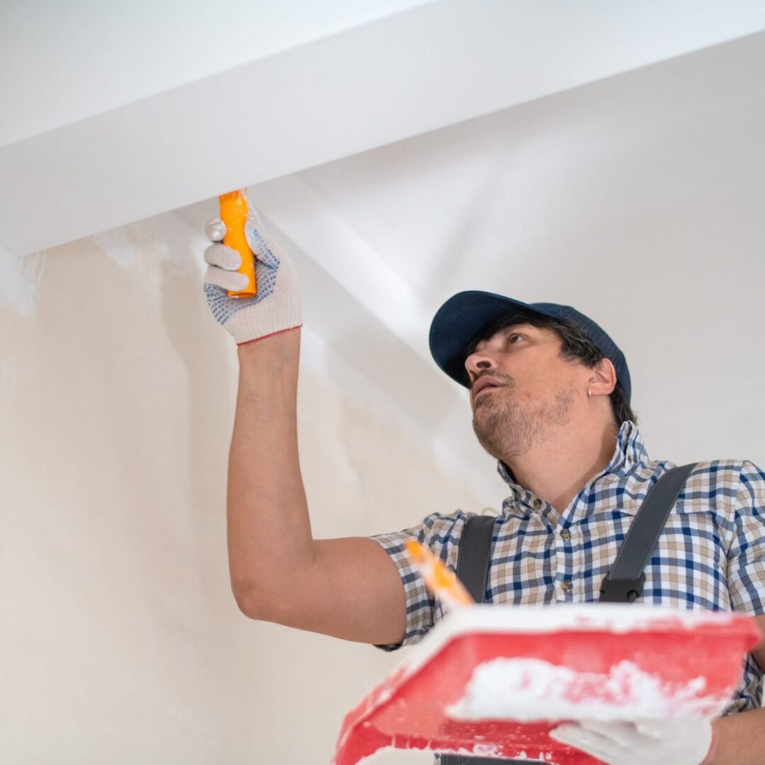 Painter working on ceiling edge