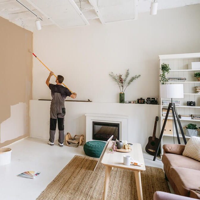 Man painting living room wall brown